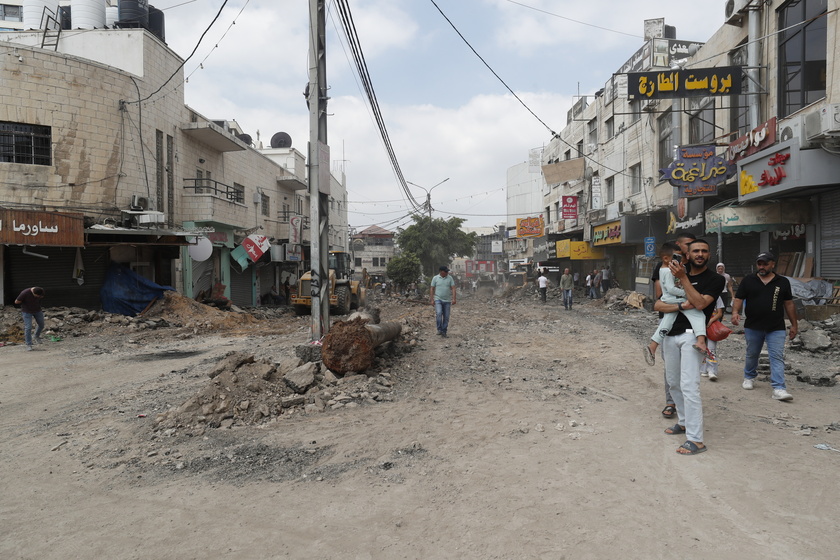 Palestinians inspect the damage after a 10-day Israeli military operation in West Bank's Jenin